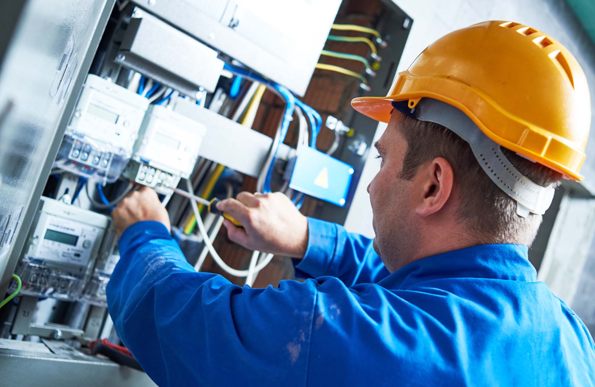 Electrician installing energy saving meter into switch box panel